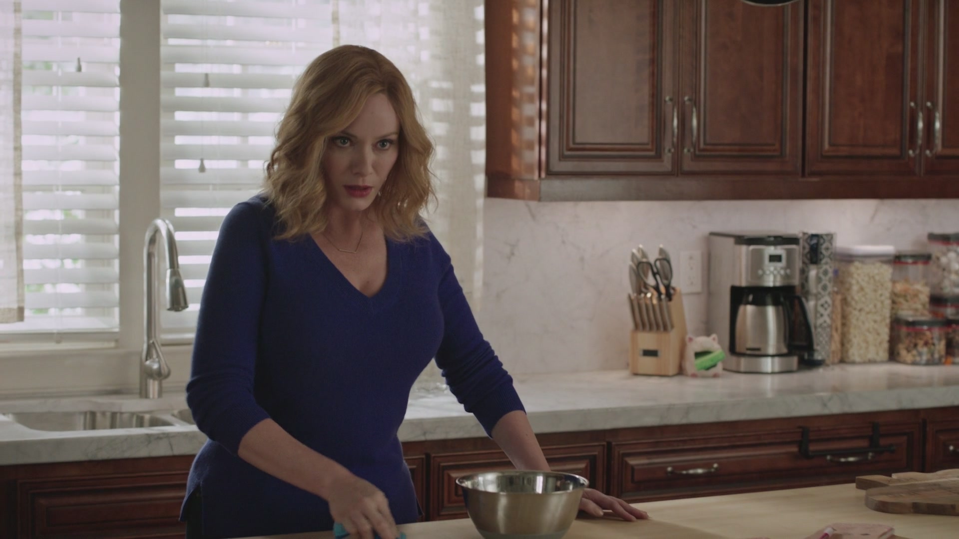 Mommy Christina behind the kitchen counter, gazing at you intently.