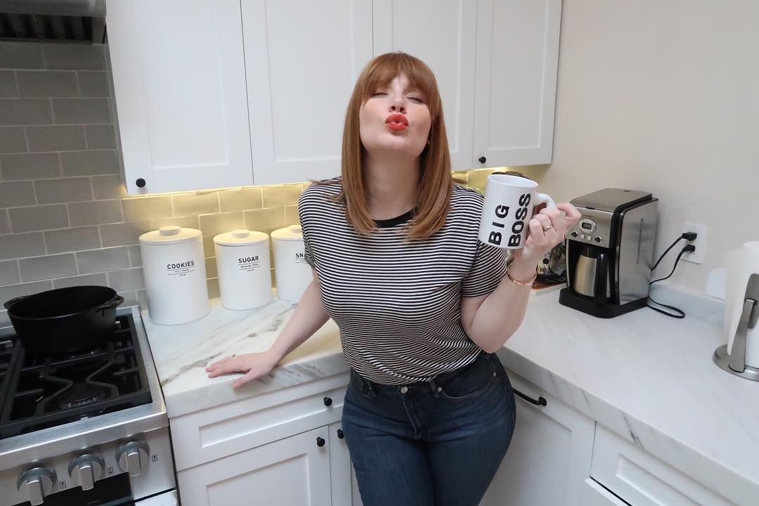 Mommy Bryce leaning against the kitchen counter still, eyes closed and lips puckered for a kiss.