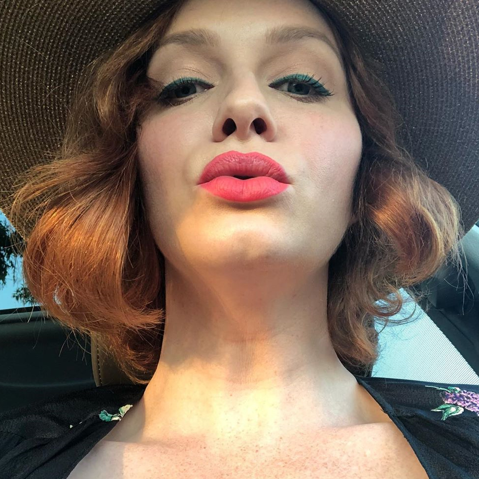 Mommy Christina in a floral dress and sun hat, looking down at you as you suckle on her nipple.